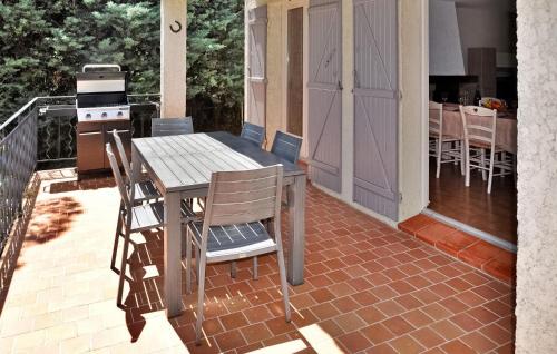 un patio avec une table et des chaises sur un balcon dans l'établissement La Villa Des Pins, à Rochefort-du-Gard