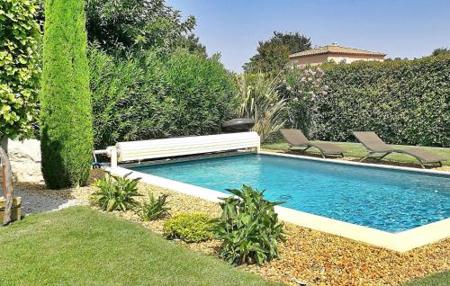 a swimming pool in a yard with two chairs next to it at Villa Nathis in Maillane