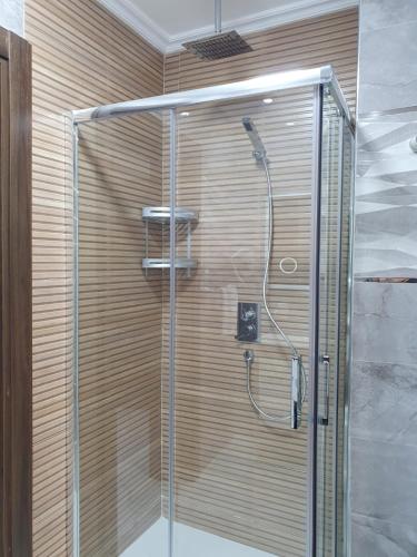 a shower with a glass door in a bathroom at Le Sélect Appartement in Nador