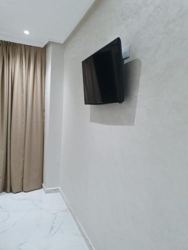 a flat screen tv on a wall in a room at Le Sélect Appartement in Nador