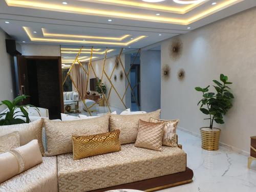 a living room with a couch with pillows on it at Le Sélect Appartement in Nador