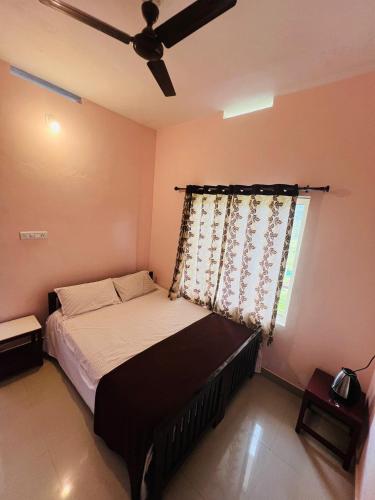 a bedroom with a bed and a ceiling fan at Kadampil Bliss in Marayoor