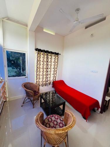 a room with a bed and chairs and a window at Kadampil Bliss in Marayoor