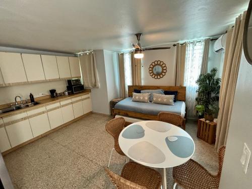cocina y sala de estar con mesa y cama en Bee Inn Puerto Rico Charming Urban Apartment in San Juan en San Juan