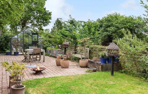 a garden with a patio with a table and chairs at 3 Bedroom Gorgeous Home In Hornbæk in Hornbæk