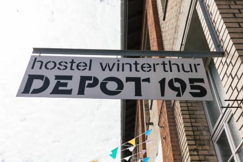 a street sign on a pole in front of a building at Depot 195 - Hostel Winterthur in Winterthur