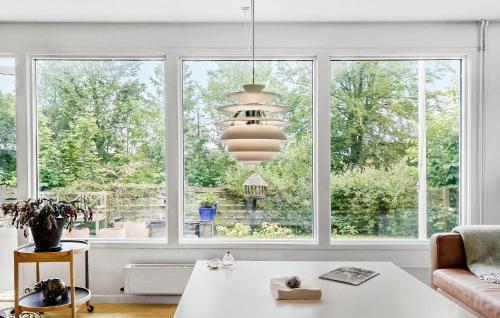 a living room with a table and a large window at 3 Bedroom Gorgeous Home In Hornbæk in Hornbæk