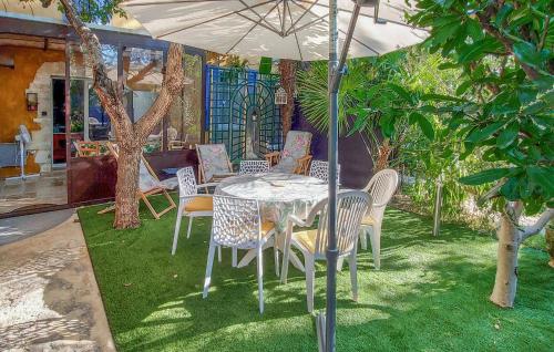 a table and chairs under an umbrella in a yard at 3 Bedroom Awesome Home In Carpentras in Carpentras