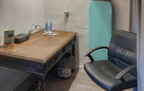 a chair sitting next to a wooden table and a desk and a chair at 3 Bedroom Awesome Home In Carpentras in Carpentras