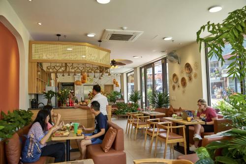 een groep mensen die aan tafel zitten in een restaurant bij Tropical paradise Hotel & Coffee in Sa Pa