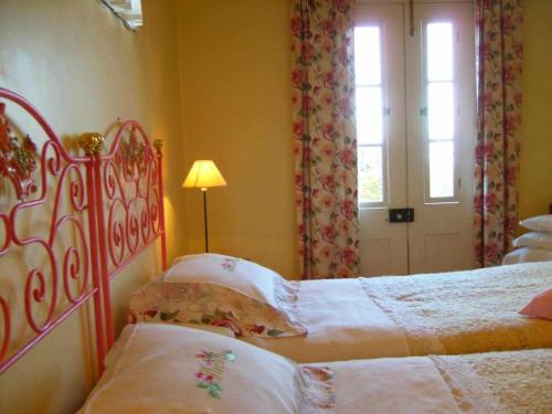 1 dormitorio con 2 camas, ventana y puerta en Quinta das Hortênsias, en Arco de São Jorge