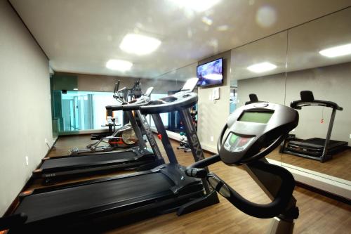 BH Raja Hotel في بيلو هوريزونتي: صالة ألعاب رياضية مع جهازين للدعسة وجهاز جري