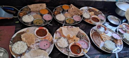 um monte de pratos de comida numa mesa em Happy Stay Villa - Kashid beach em Kashid