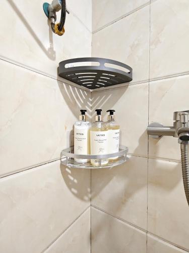 a shelf in a bathroom with three bottles of soap at SKYINN Aparment 橙堡整套复式公寓 in Shenzhen