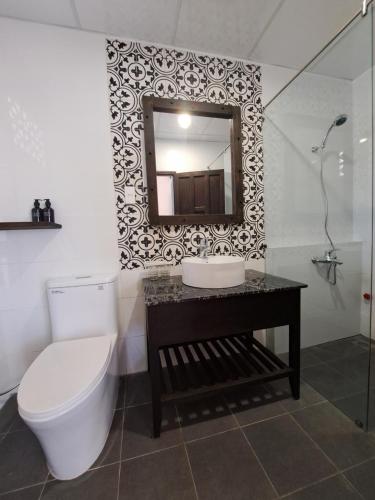 a bathroom with a toilet and a sink and a mirror at La nho House in Ninh Hải