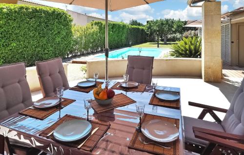 une table à manger avec un parasol sur une terrasse dans l'établissement Villa Castillon, à Paradou