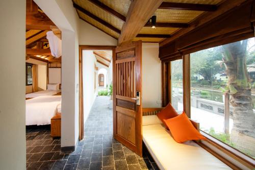 Cette chambre comprend un lit et une fenêtre. dans l'établissement Mua Caves Ecolodge (Hang Mua), à Ninh Binh