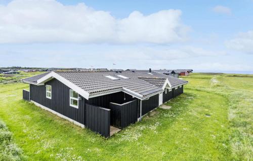 una casa nera in un campo con erba di 4 Bedroom Stunning Home In Hjørring a Hjørring