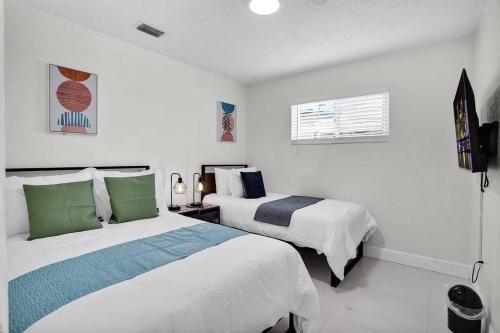 a bedroom with two beds and a window at Ventur Oasis Lux Hollywood Private Pool Retreat in Hollywood