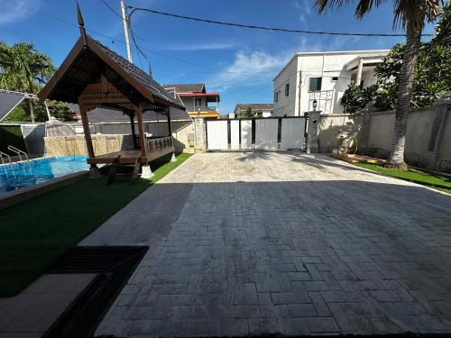 a patio with a gazebo next to a house at Mawar 23 Chendering with Private Pool in Kuala Terengganu