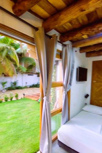 a bedroom with a bed and a window at Cabañas Barikoke-Fiji in Moñitos