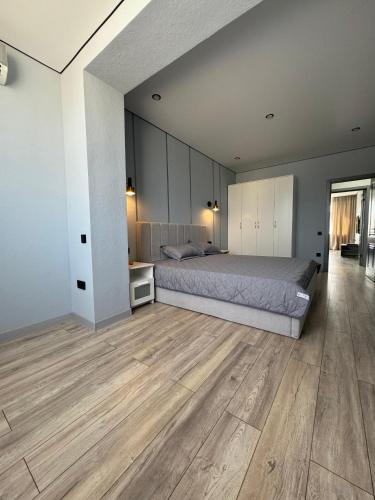 une chambre avec un lit et un parquet dans l'établissement Шикарная квартира в центре! Делаем документы!, à Aktau