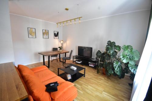a living room with an orange couch and a table at Apartamenty Basztowa in Świdnica