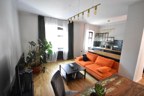 a living room with an orange couch and a table at Apartamenty Basztowa in Świdnica