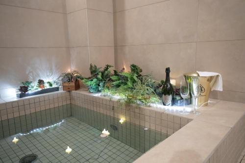 a bathroom with plants on a tiled ledge at CREWSO Designers house for max 16ppl in Osaka