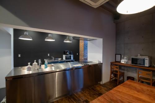 a kitchen with two sinks and a counter with a microwave at CREWSO Designers house for max 16ppl in Osaka