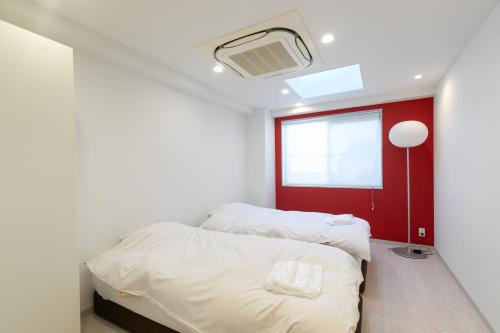 Un dormitorio con dos camas y una ventana. en CREWSO Designers house for max 16ppl, en Osaka