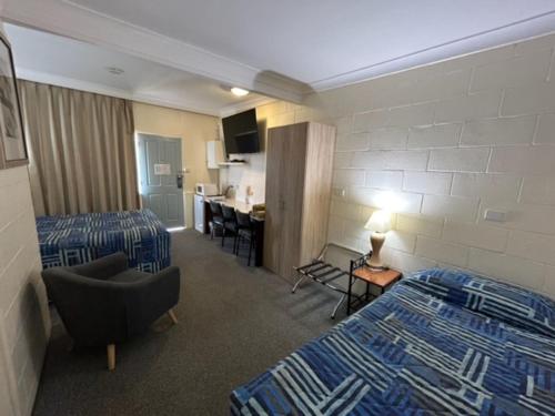 ein Hotelzimmer mit 2 Betten und einem Schreibtisch in der Unterkunft Warren Motor Inn in Warren
