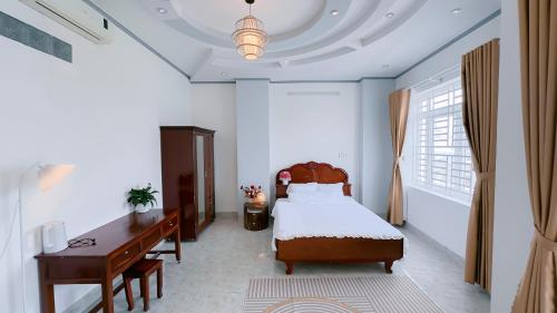 a bedroom with a bed and a desk and a bed sidx sidx sidx at Miha Villa Can Tho in Can Tho