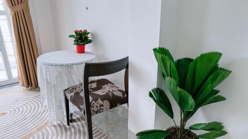 a table and a chair in a room with a plant at Miha Villa Can Tho in Can Tho