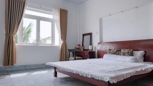 a bedroom with a large bed and a window at Miha Villa Can Tho in Can Tho