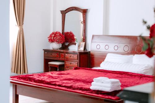 a bedroom with a red bed and a mirror at Miha Villa Can Tho in Can Tho