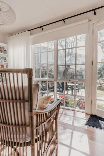 a cat sitting in a chair in front of a window at Edge17 Waterfront Apartment, plus Cottage with Garden View - Port Fairy in Port Fairy