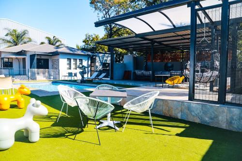 a backyard with chairs and a table and a pool at One Home in Pretoria