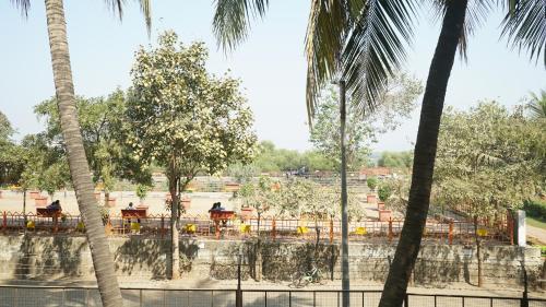 a view of a park with palm trees and a fountain at NANDINI BUNGLOw in Thane