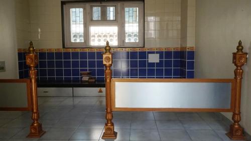 a room with a bench and a window and blue tiles at NANDINI BUNGLOw in Thane