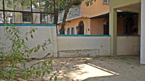 an empty building with a wall and a tree at NANDINI BUNGLOw in Thane
