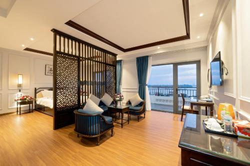 a hotel room with a bedroom and a living room at Eco Lux Riverside Hotel & Spa in Hoi An