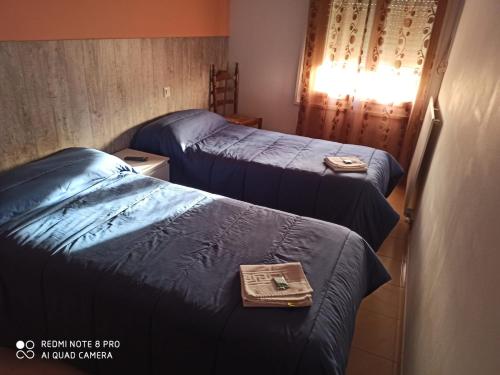 a hotel room with two beds with a tray on it at Hostal Galicia in Figueres