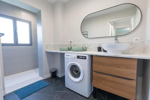 une salle de bain avec une machine à laver et un lavabo dans l'établissement Appartement « Villa Josy » cosy à Argelès-Gazost avec jardin, à Argelès-Gazost