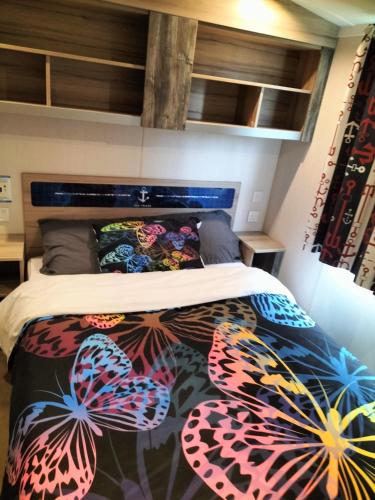 een slaapkamer met een bed met kleurrijke vlinderkussens bij Haven Holiday Park 3 bedroom Cala Gran Fleetwood in Thornton