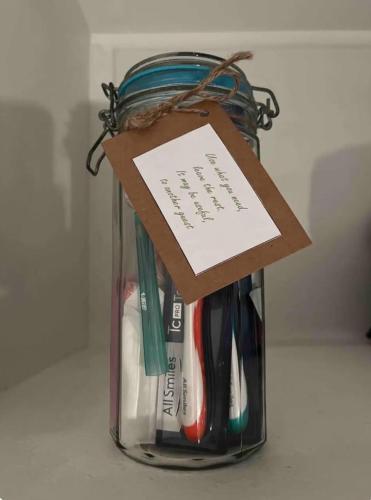 a jar full of utensils with a card on it at Wattle Creek Studio with Breakfast Basket in Amberley
