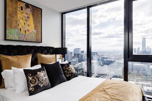 Un dormitorio con una cama blanca con una ventana grande. en VAQUAY Luxor In Southbank, en Melbourne