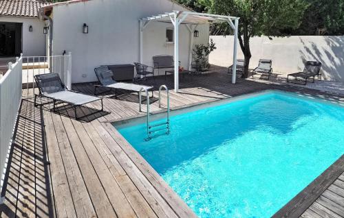 einen Pool mit einem Tisch und Stühlen neben einem Haus in der Unterkunft La Villa De Maussane in Maussane-les-Alpilles