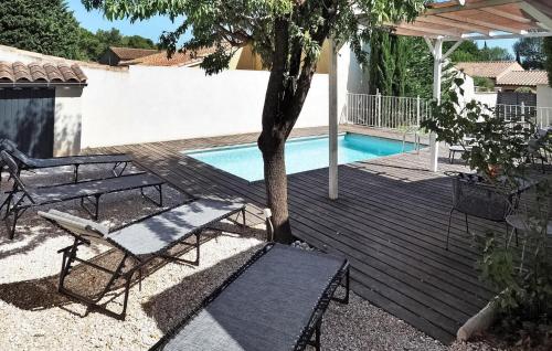 une terrasse en bois avec une table et un banc à côté d'une piscine dans l'établissement La Villa De Maussane, à Maussane-les-Alpilles