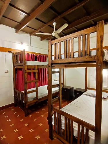 two bunk beds in a room with a ceiling at Bunk Club Hostel in Vandiperiyār
